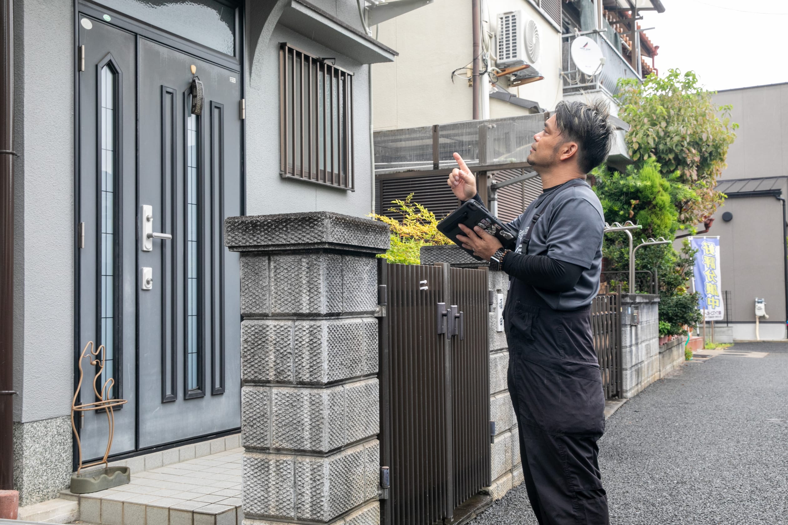 住宅の外観を確認するスタッフ